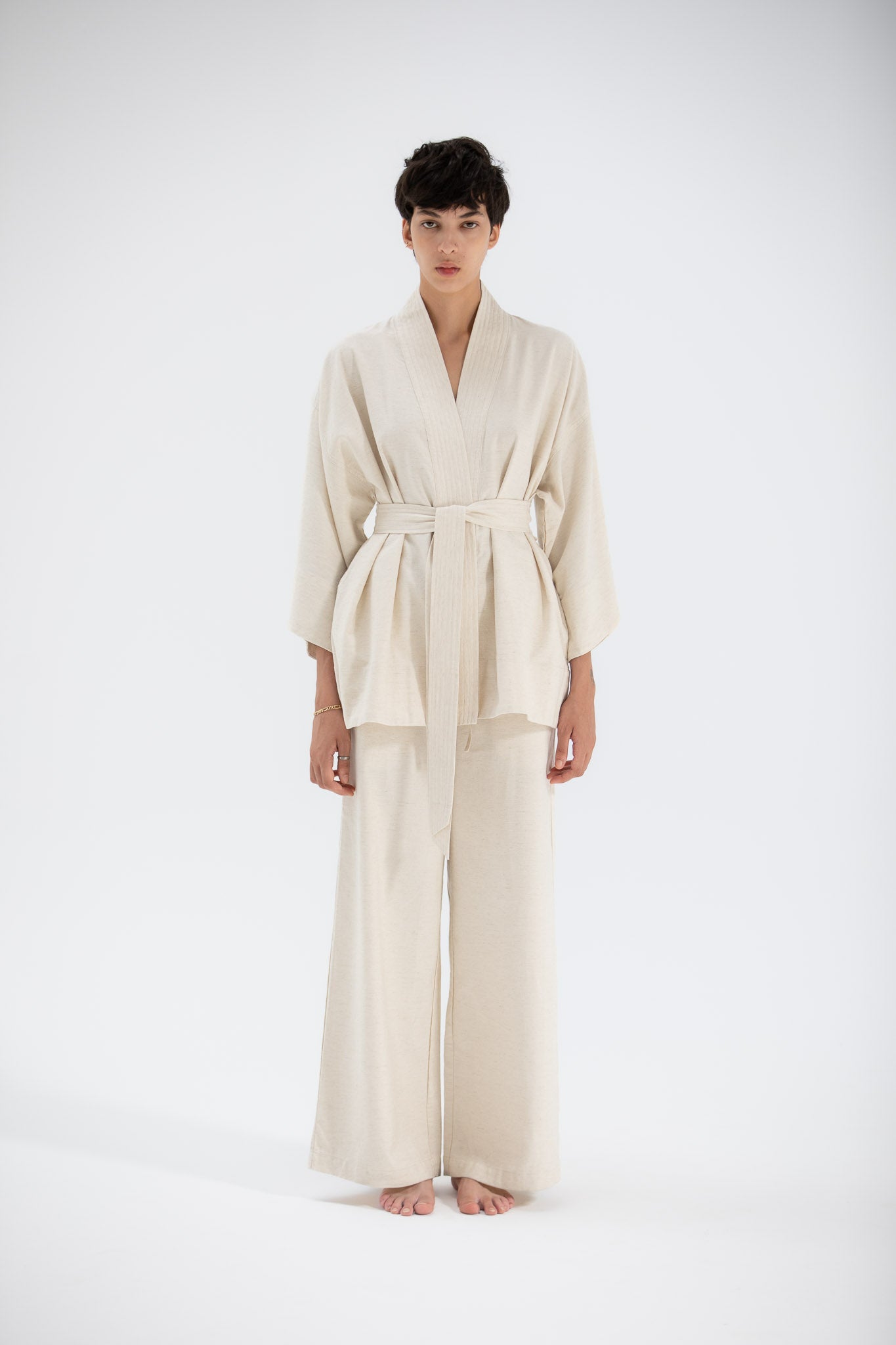 Model wearing a beige linen kimono jacket made by atelier mizuni.