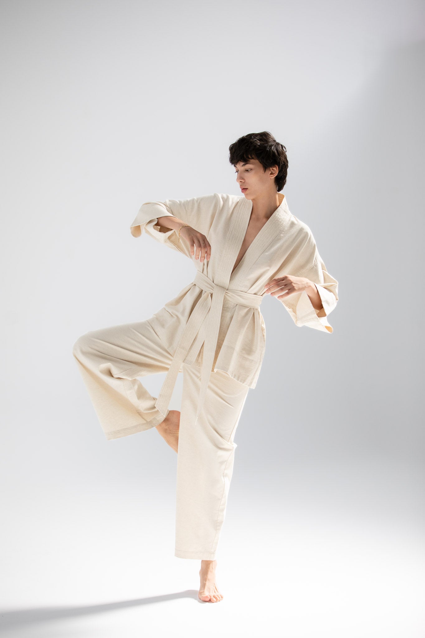 Person wearing a cream-colored kimono jacket made from atelier mizuni.