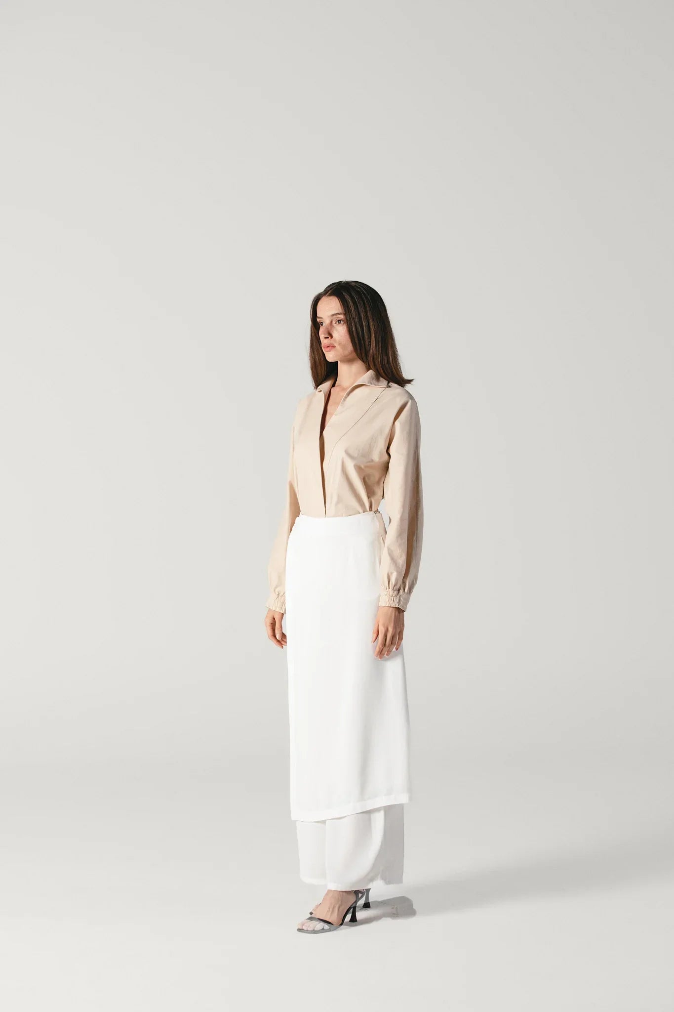 Model posing with a viscose white pants with attachable skirt by Atelier Mizuni japanese style