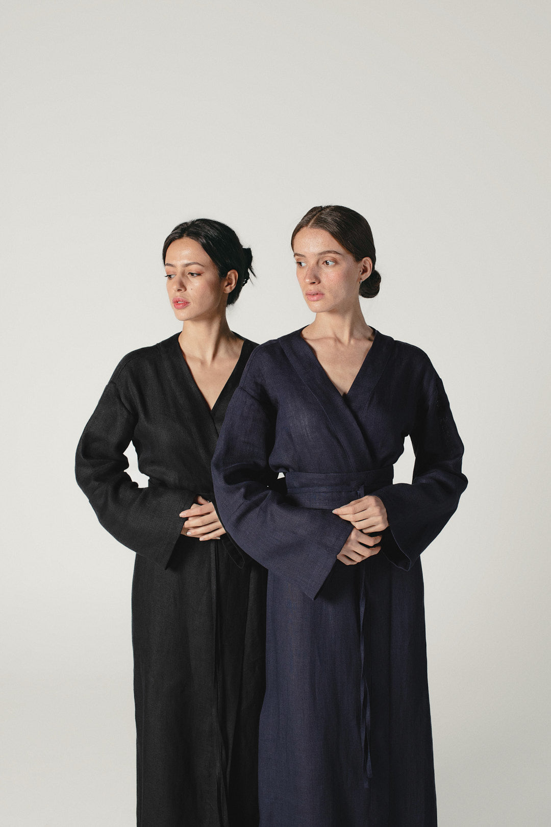 Two models wearing black and blue linen kimono dresses by Atelier Mizuni, exemplifying sustainable fashion elegance