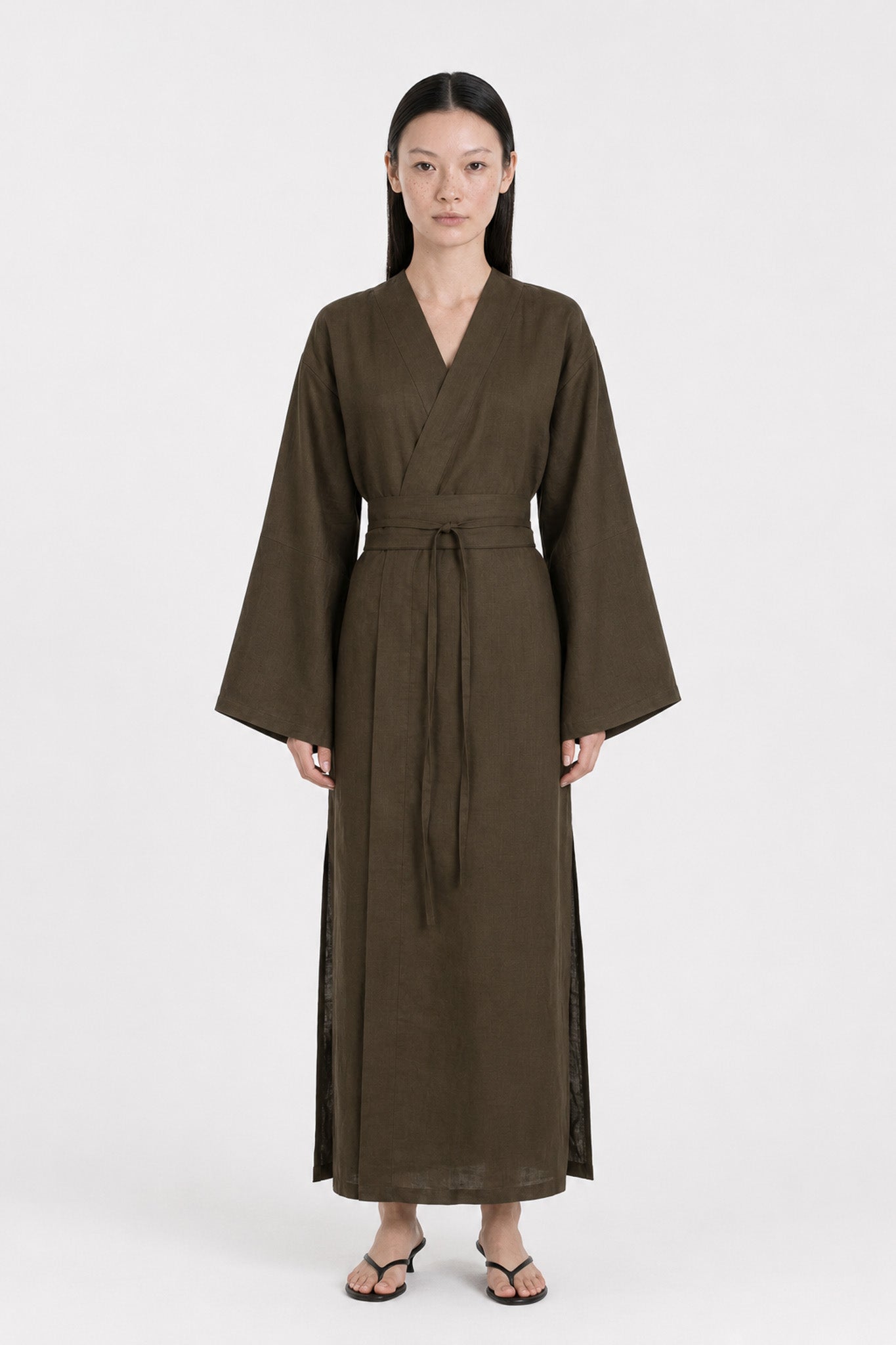 A  model wearing a Dark Olive Linen kimono dress made by atelier mizuni