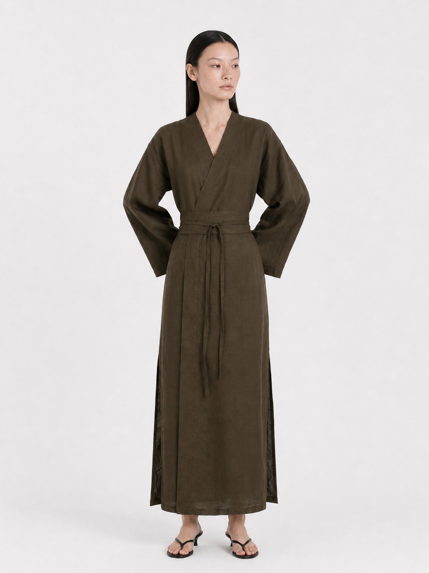 A  model wearing a Dark Olive Linen kimono dress made by atelier mizuni