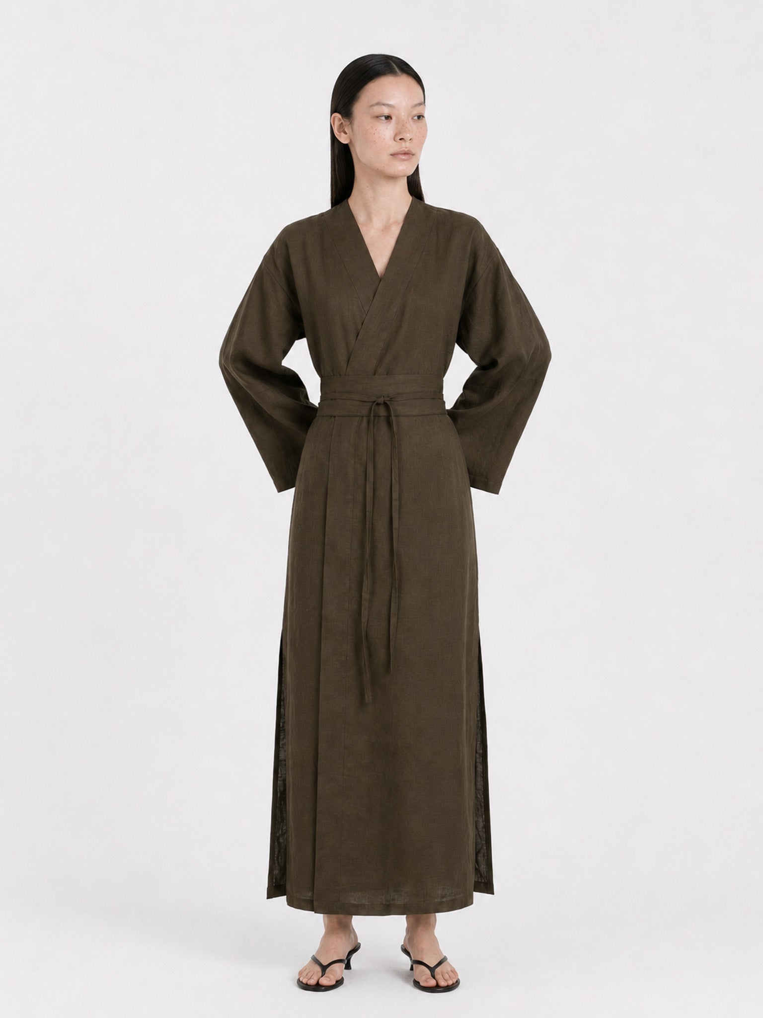 A  model wearing a Dark Olive Linen kimono dress made by atelier mizuni