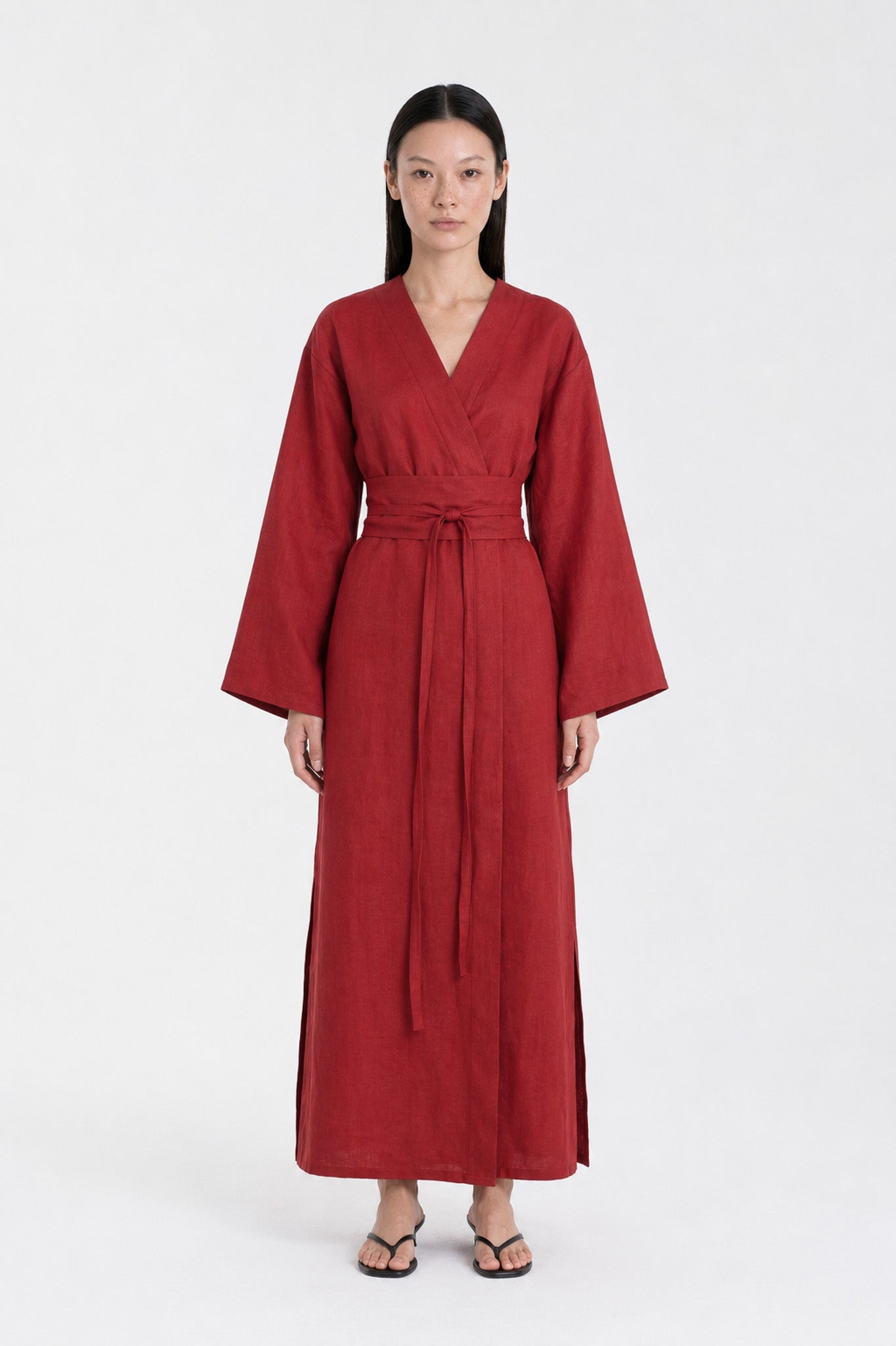 A  model wearing a Red Wine linen kimono dress made by atelier mizuni