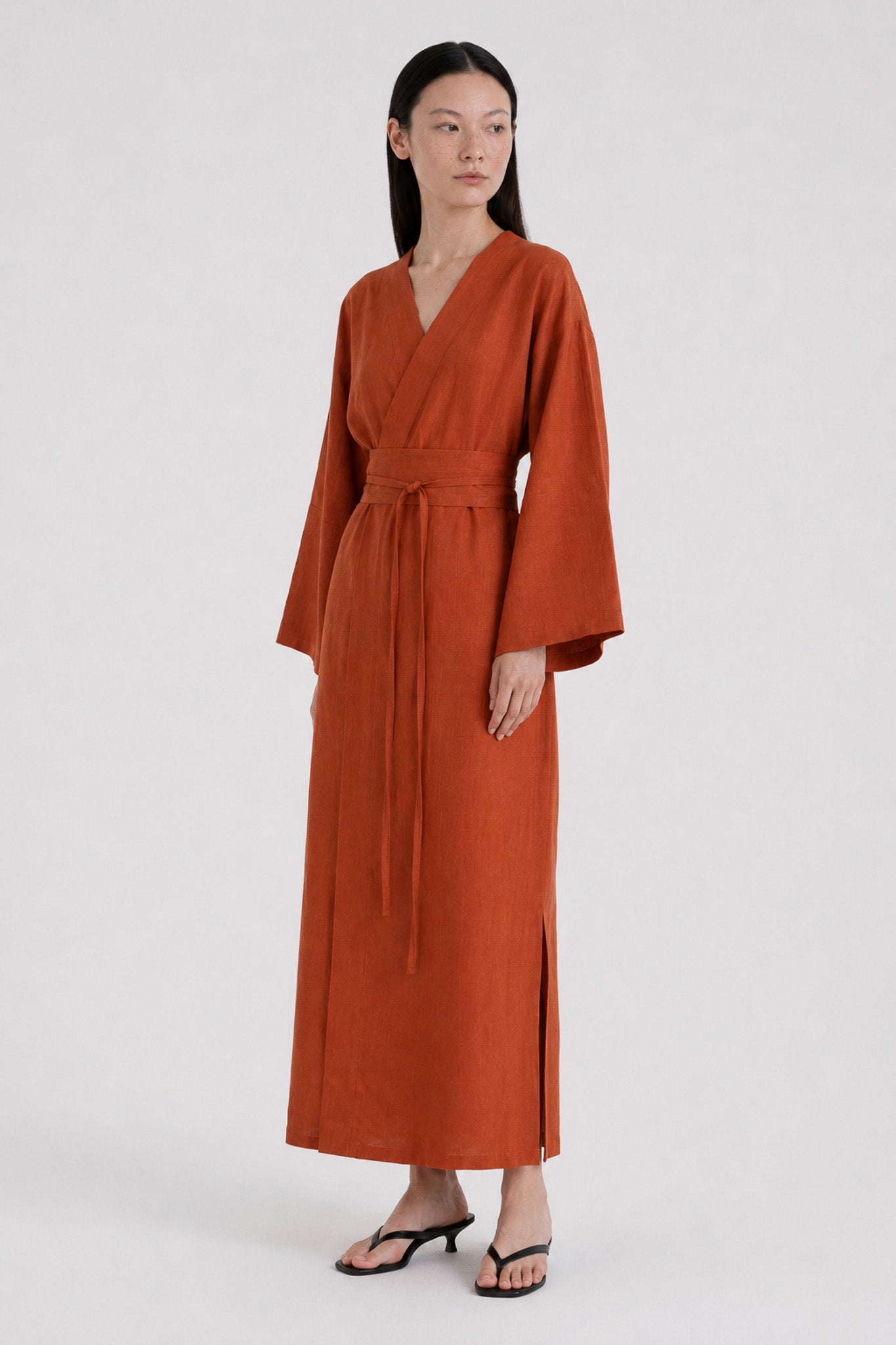 Woman wearing a terracotta kimono dress made of pure linen 