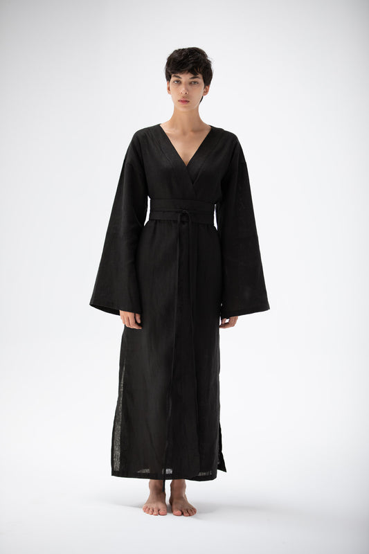Woman wearing a black kimono dress with wild sleeves made of pure linen.
