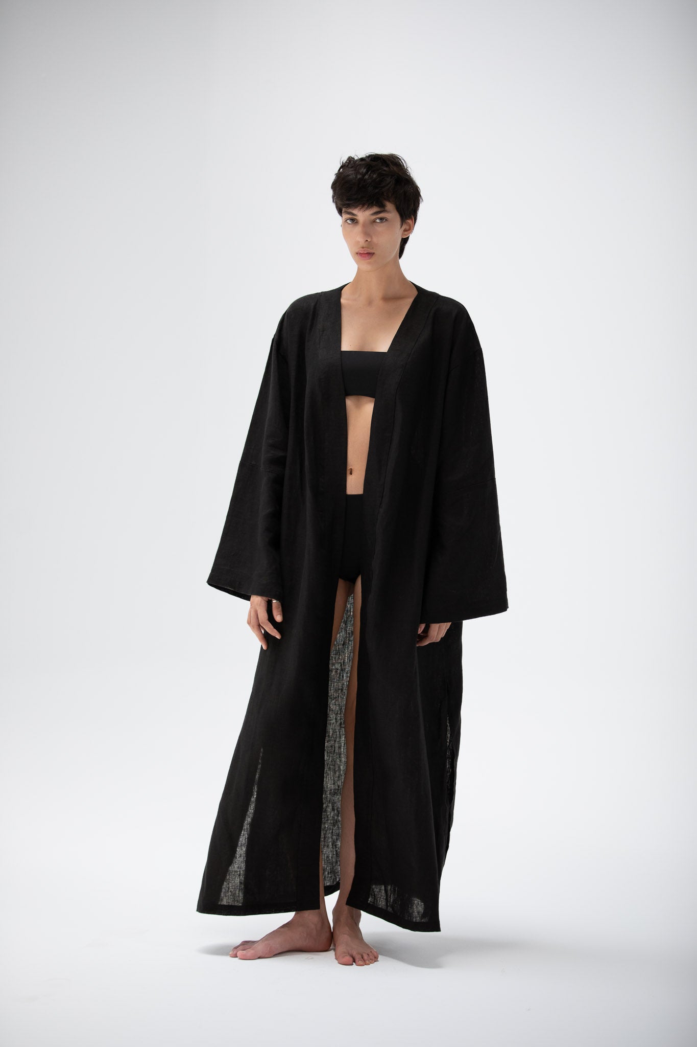 Model wearing a black linen kimono dress designed by atelier mizuni.