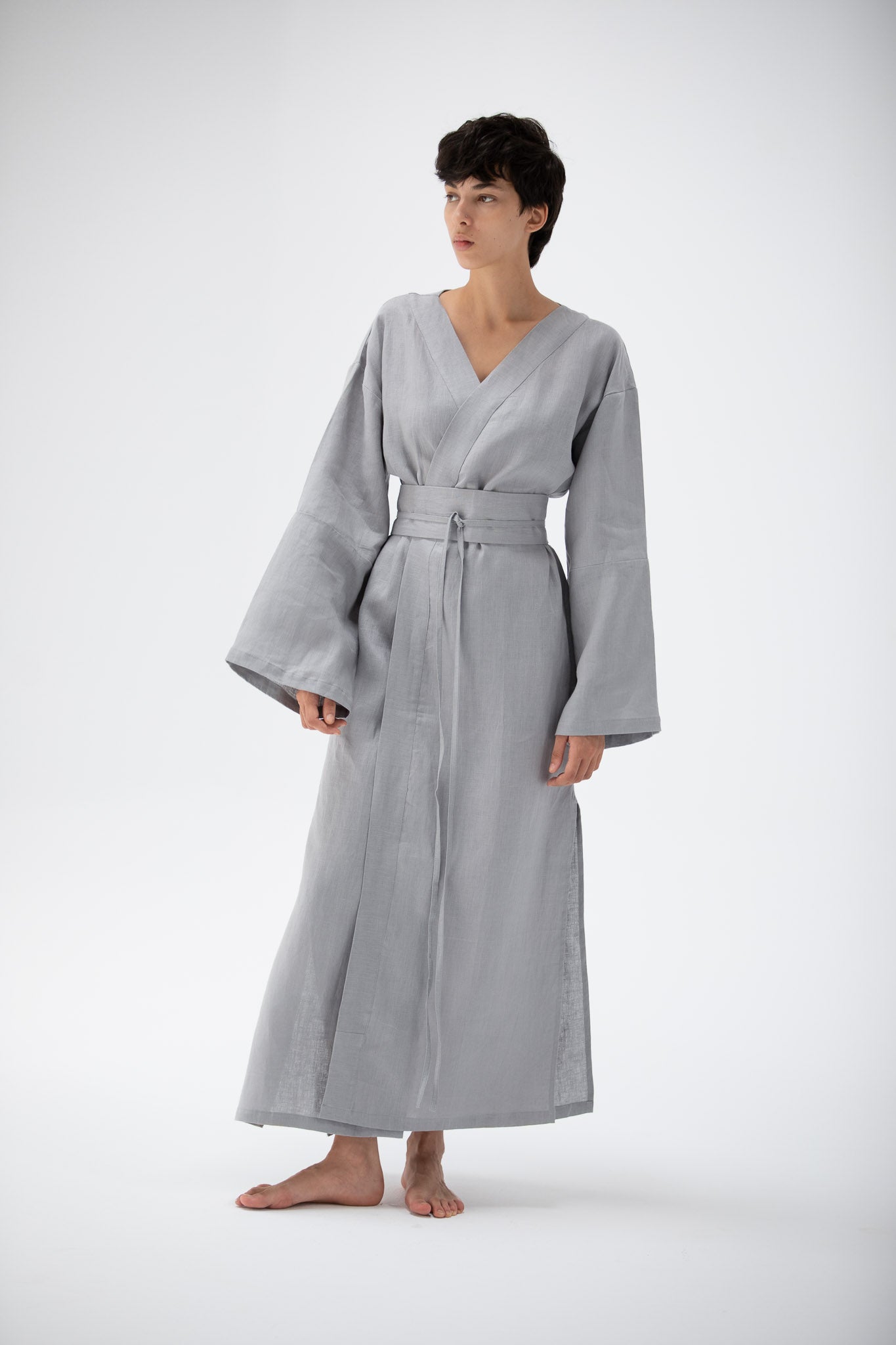 Woman wearing a gray blue linen kimono dress designed by atelier mizuni