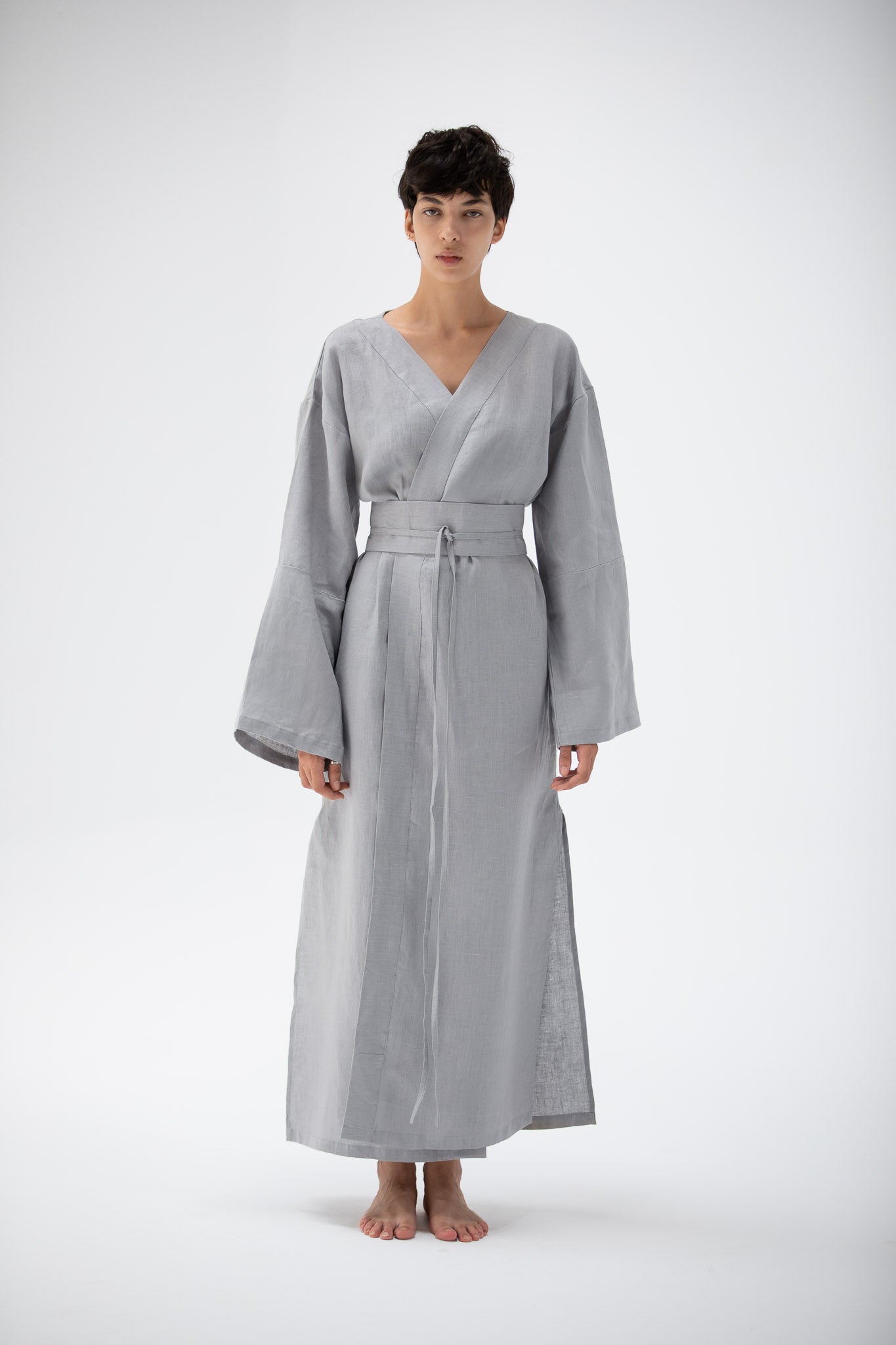 Woman wearing a gray blue kimono dress made of pure linen designed by atelier mizuni.