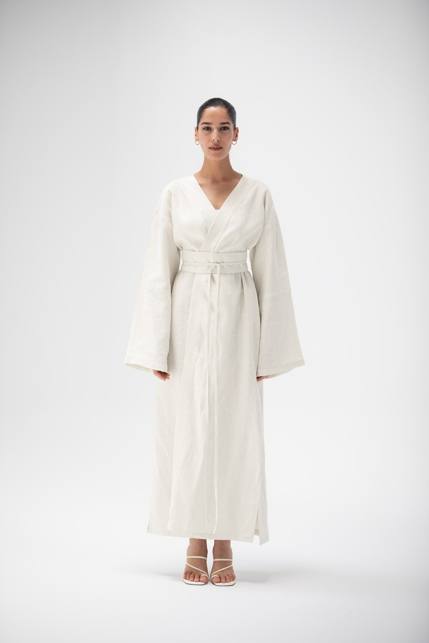 Woman wearing an ivory kimono dress made of pure linen by atelier mizuni on a white background