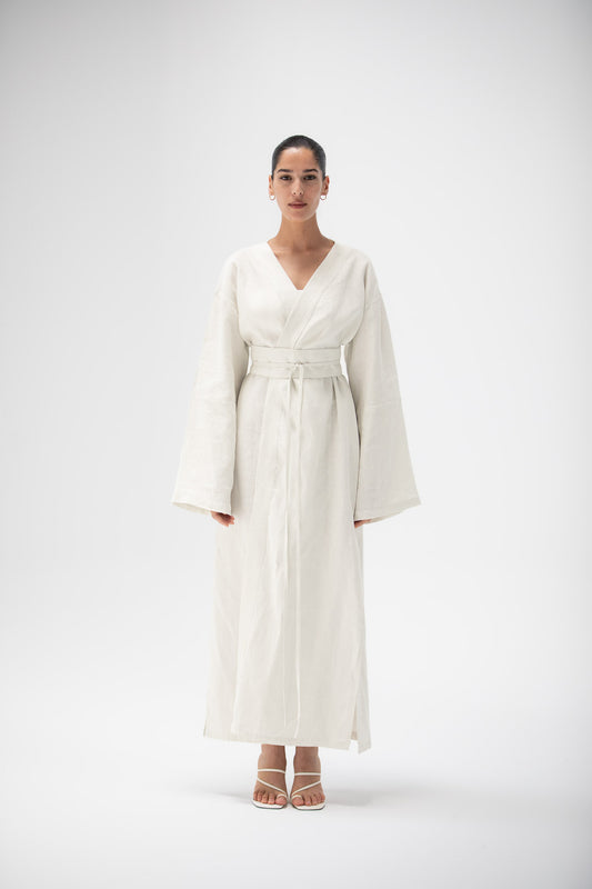 Woman wearing an ivory kimono dress made of pure linen by atelier mizuni on a white background