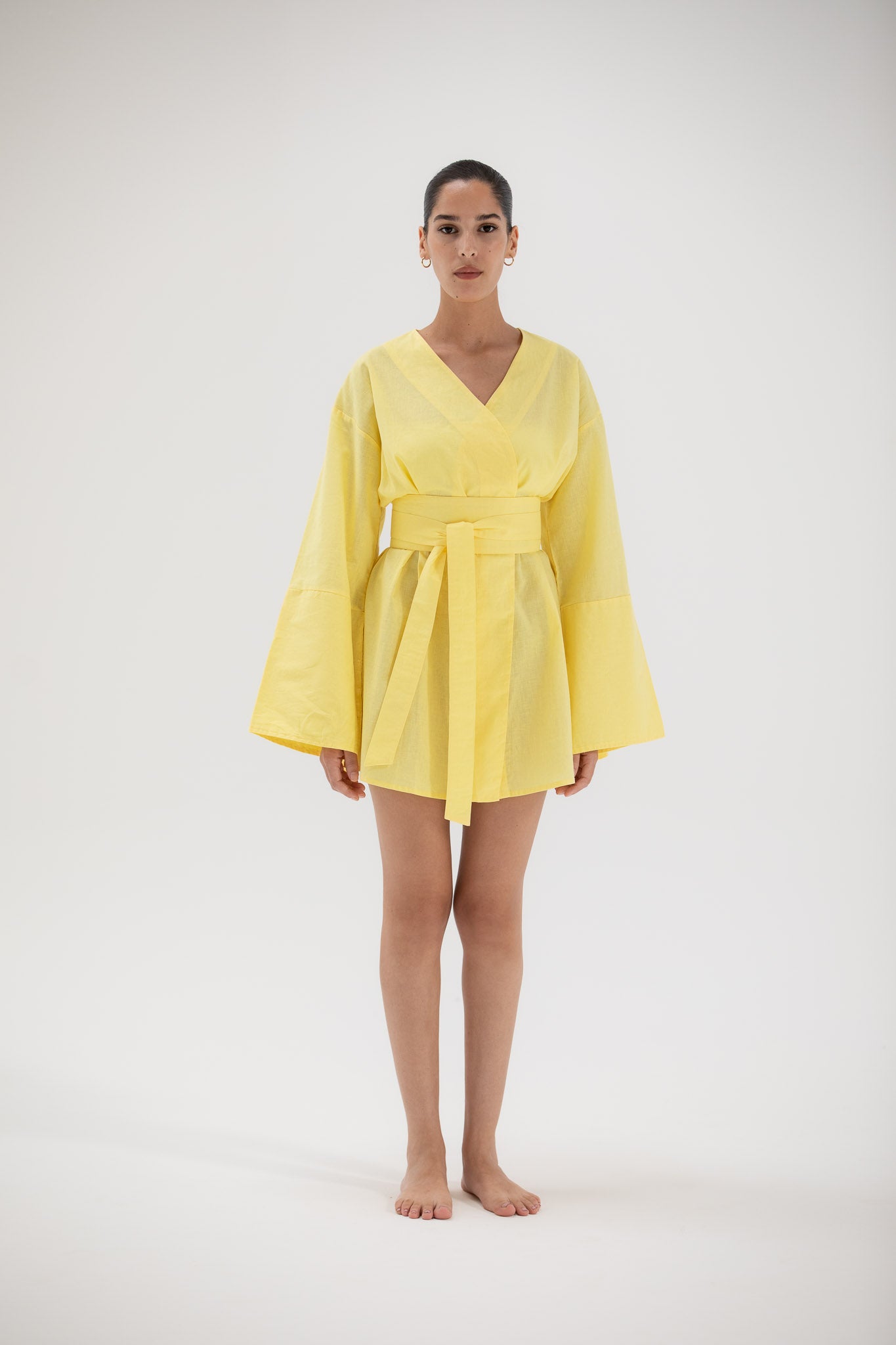 Woman wearing a short yellow kimono dress made of linen designed by atelier mizuni