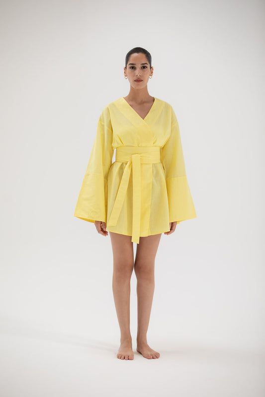Woman wearing a short yellow kimono dress made of linen designed by atelier mizuni