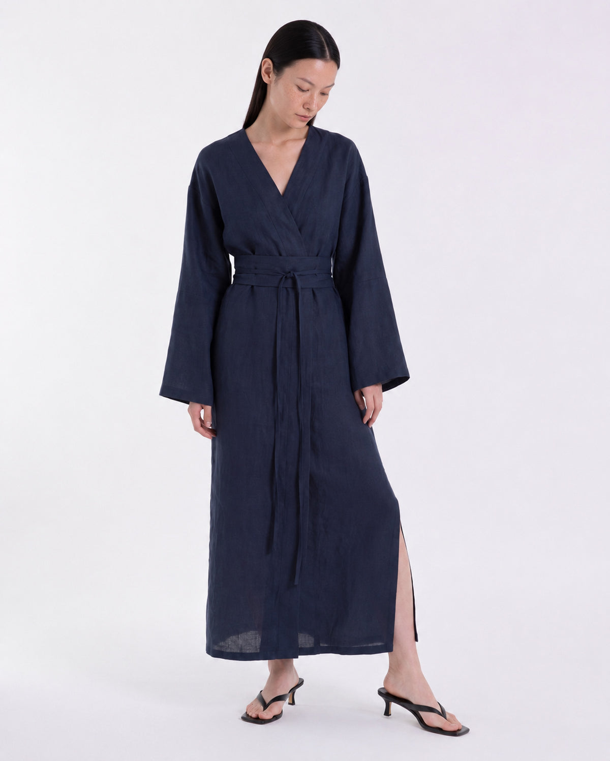 Model wearing a midnight blue linen kimono-style wrap dress