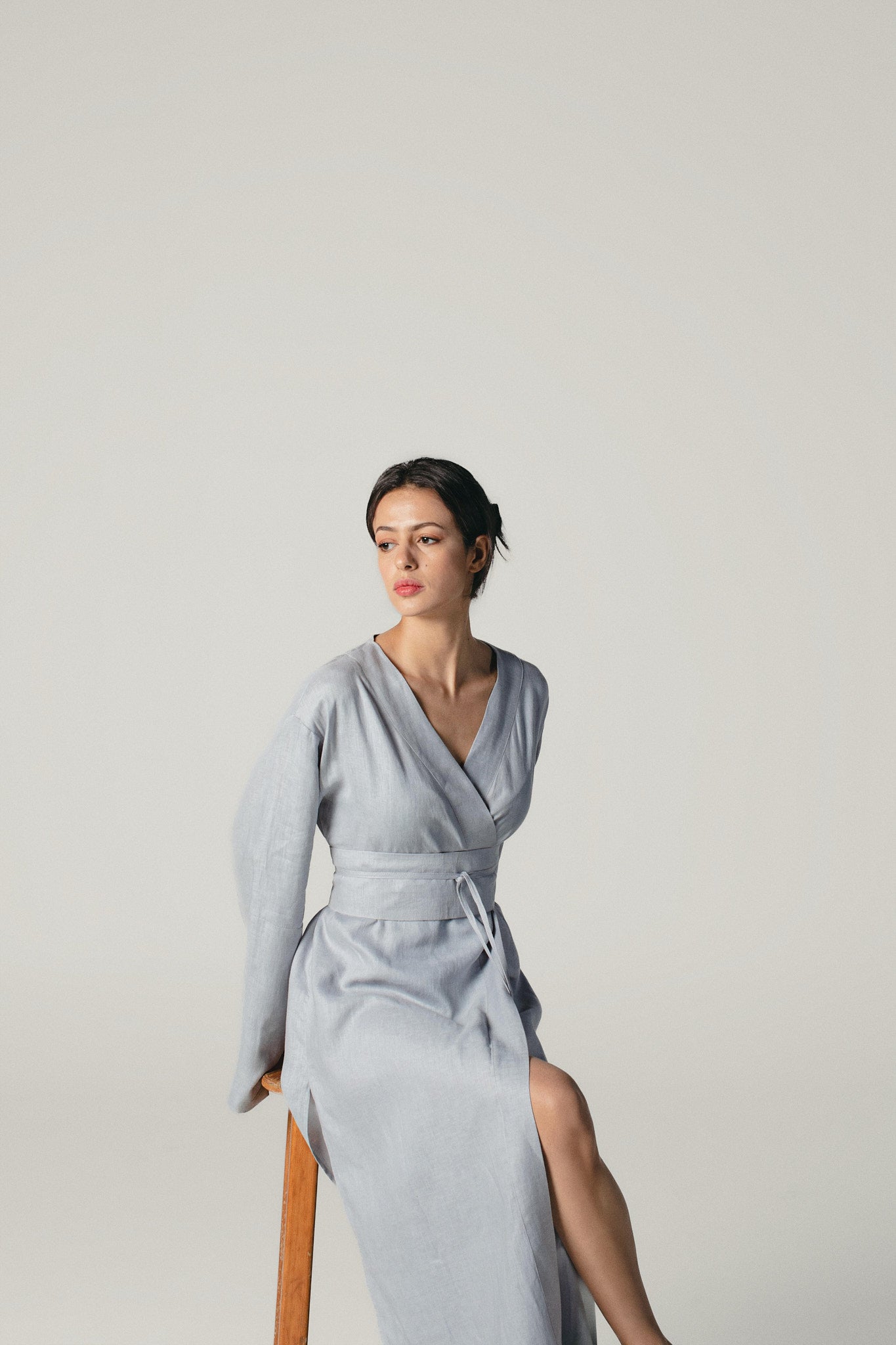 model sitting on a chair wearing a Grey Blue linen kimono dress