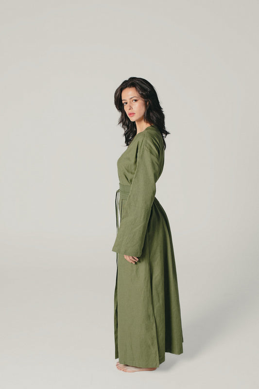 A side shot of a model wearing an Olive Green linen kimono dress made by atelier mizuni