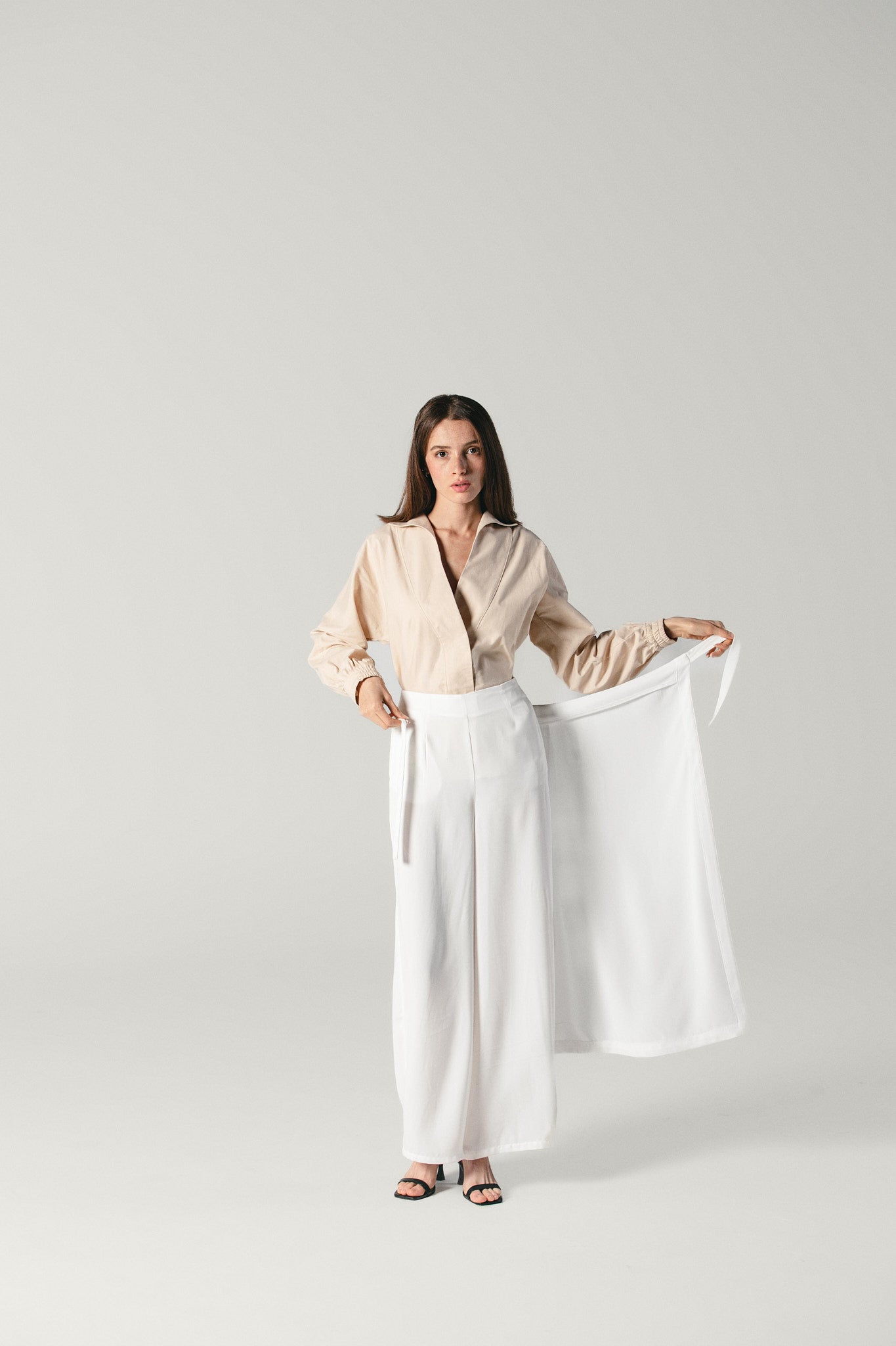 viscose white pants with attachable skirt by Atelier Mizuni, displaying how to attach the skirt to the pants with ease